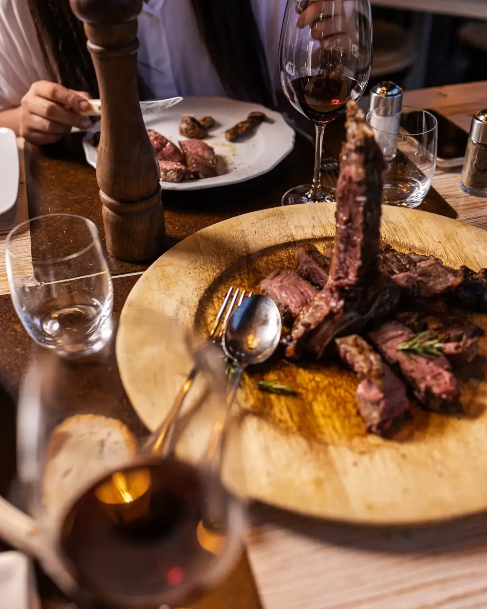 Fiorentina di Chianina servita sul tagliere con un calice di vino rosso