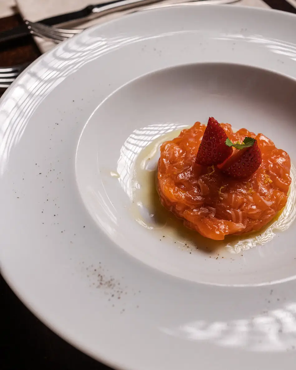 Tartare di pesce con fragole servita nel piatto bianco
