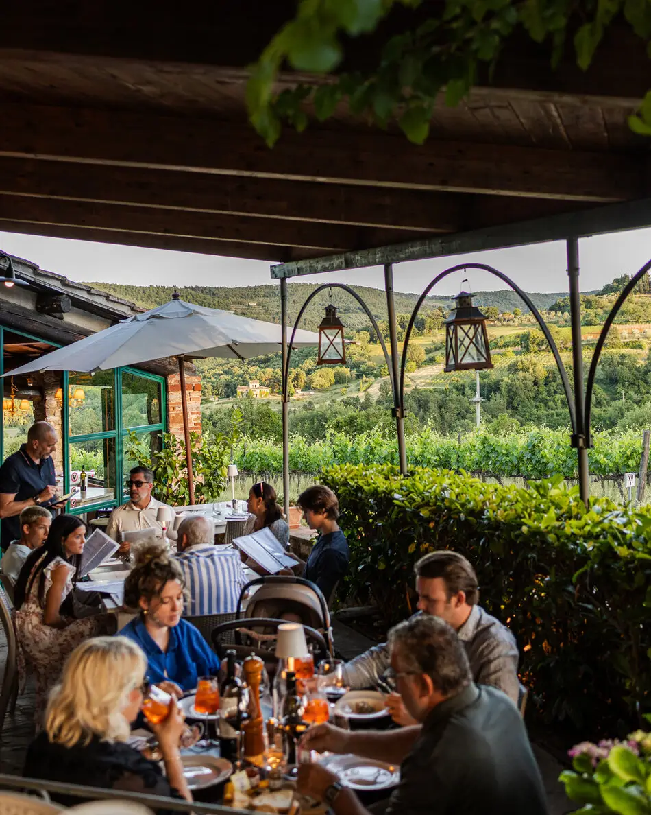 La terrazza dell'Osteria alla Piazza piena di ospiti a cena al tramonto